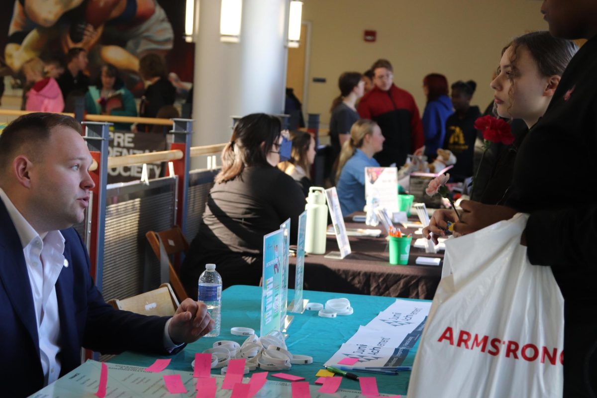 Grant Filbeck (left) from Junior Achievement explains the nonprofit’s efforts of teaching financial literacy, workforce readiness and entrepreneurship so students can think about their plans after school.